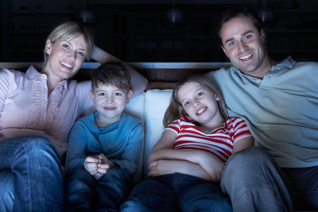 Family Watching TV On Sofa Together