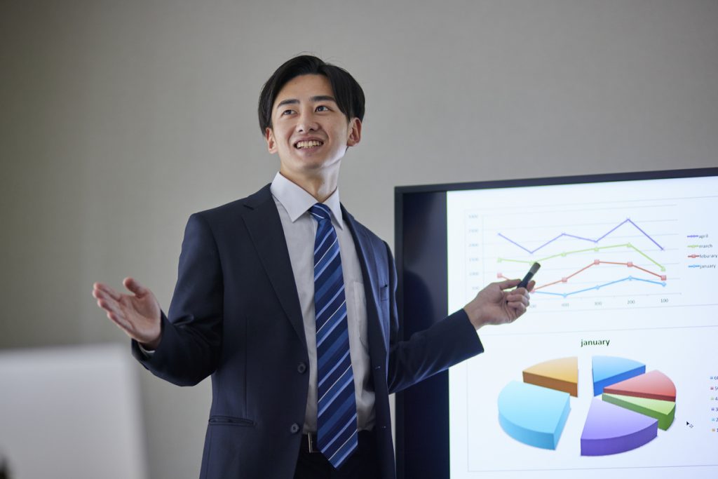 Japanese businessman wearing a suit giving a presentation