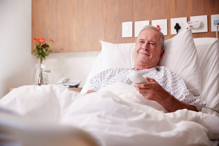 old man in bed enjoys tv