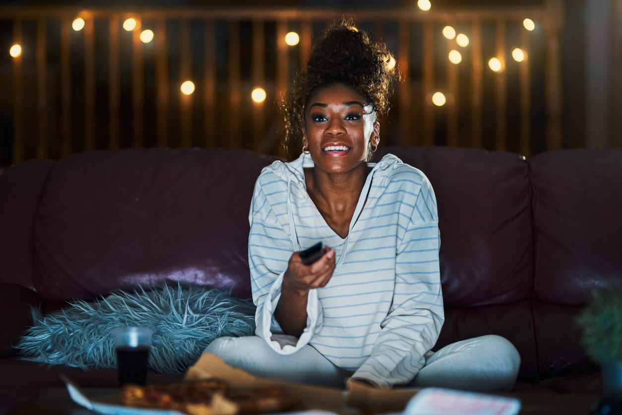 woman in pajamas staying up late at night eating pizza