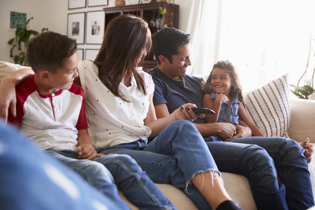 Family sitting on the sofa at home to watch TV