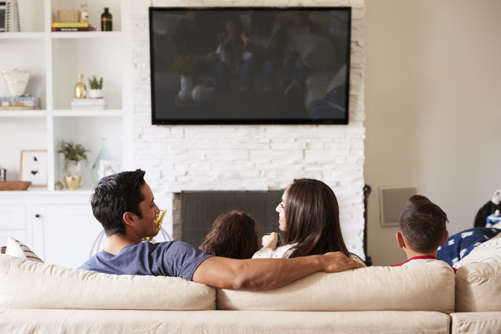 Family on sofa watching smart tv