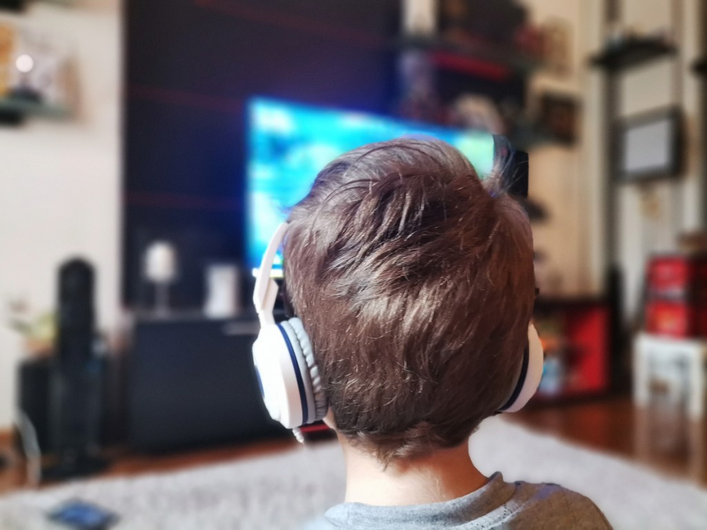Child watching smart TV with wireless headphones