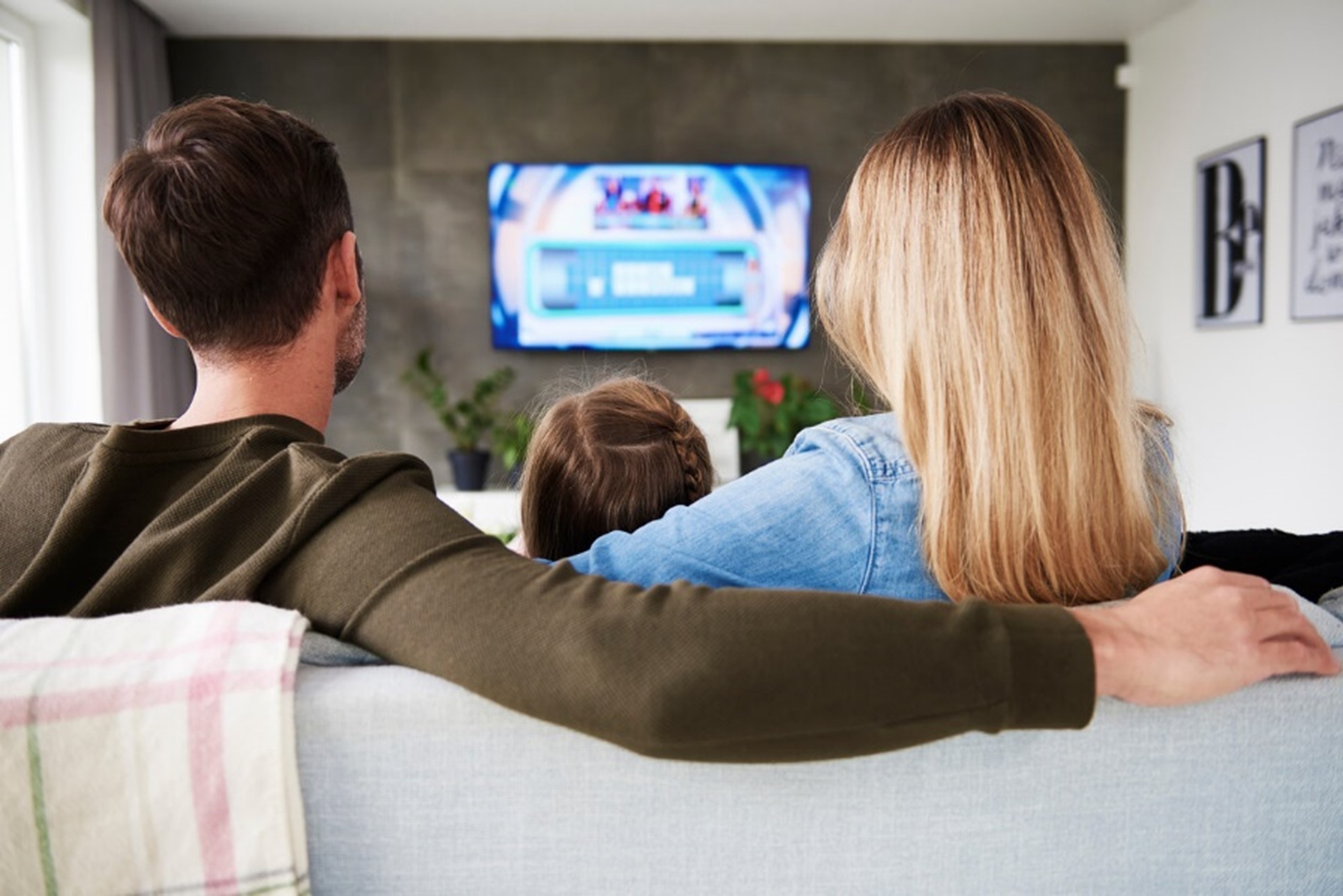 Family gathering round an LED TV